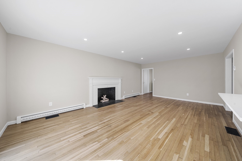 4 Fox Run Road Bedford, MA 01730 - Photo 16 of 42 a view of empty room with wooden floor and fireplace