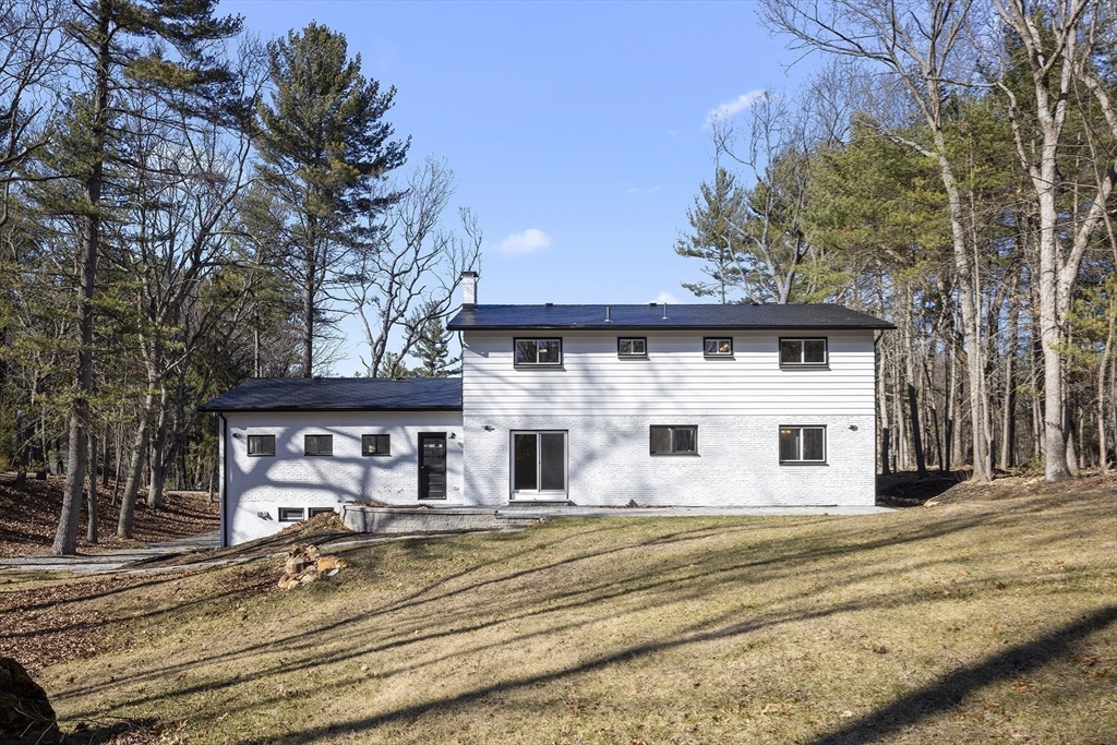 4 Fox Run Road Bedford, MA 01730 - Photo 38 of 42 a view of a white house with a large tree and wooden fence