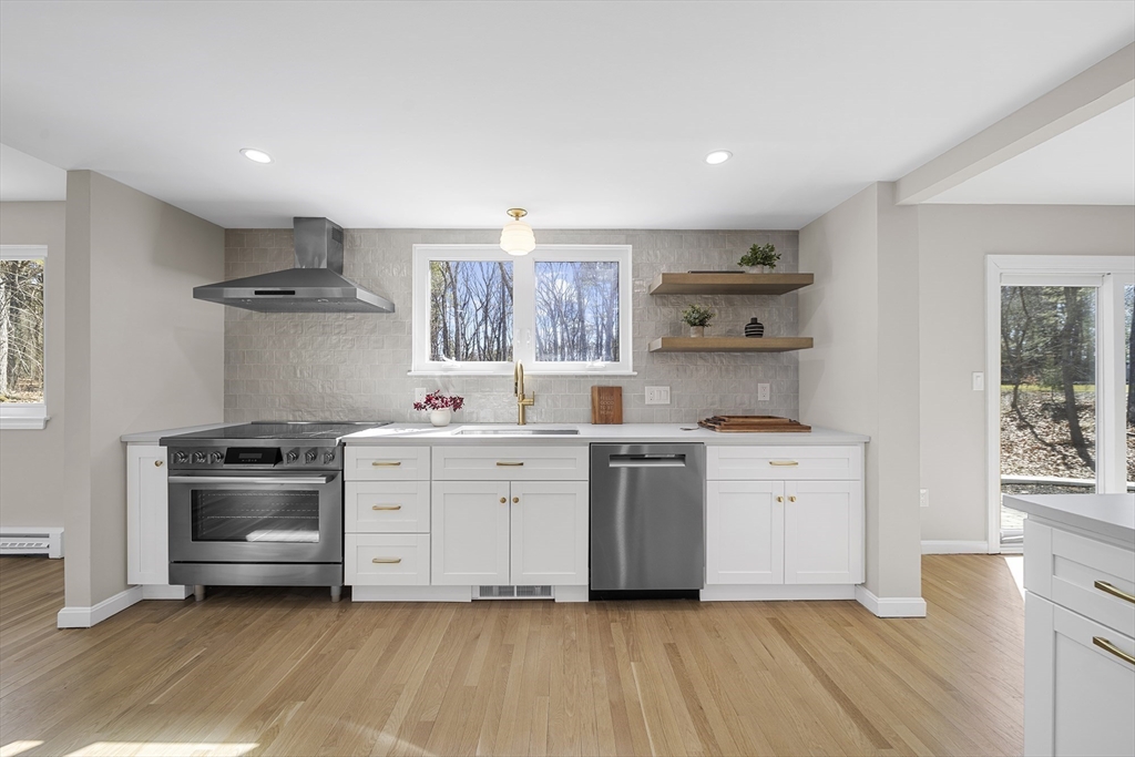 4 Fox Run Road Bedford, MA 01730 - Photo 8 of 42 a kitchen with stainless steel appliances a stove a sink and white cabinets with wooden floor