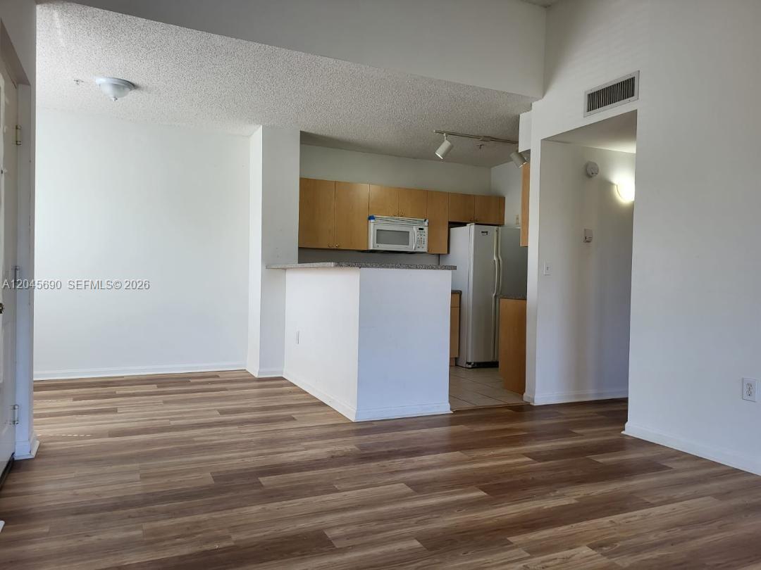 8070 North Nob Hill Road, Unit 208 Tamarac, FL 33321 - Photo 7 of 16 a view of a hallway with wooden floor and a bathroom