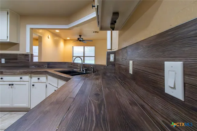 a kitchen with granite countertop a refrigerator and a stove top oven