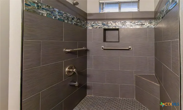 a bathroom with a granite countertop toilet and a shower