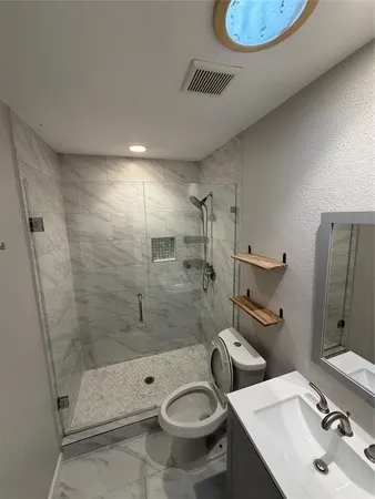 a bathroom with a sink toilet and shower