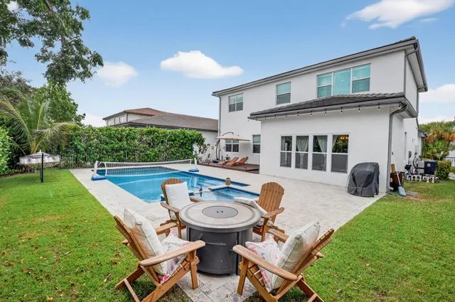 an aerial view of a residential houses with outdoor space and lake view