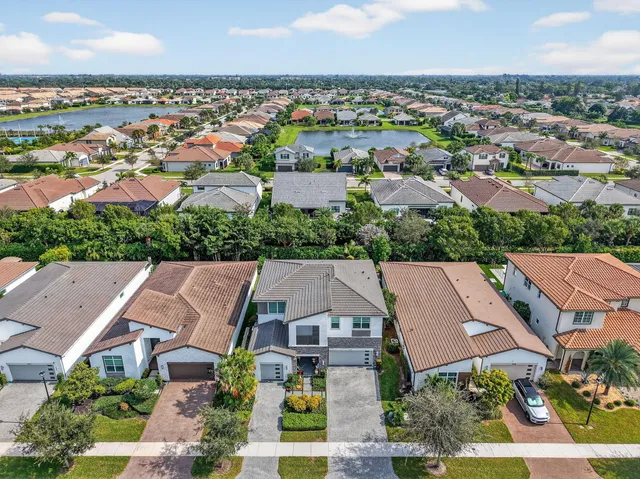 an aerial view of a swimming pool with a yard and lake view