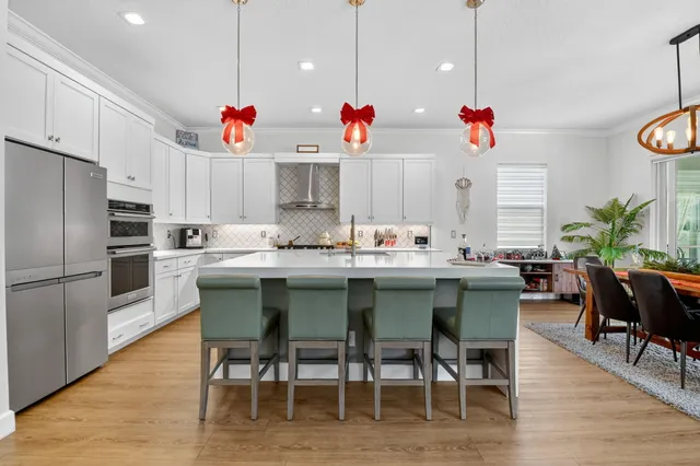 a kitchen with stainless steel appliances a sink a stove and a wooden floors