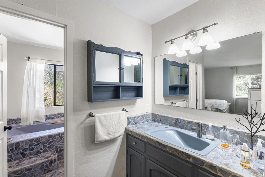 3340 Skytrail Ranch Road Jamul, CA 91935 - Photo 18 of 38 a en suite bathroom with a granite countertop sink and a mirror