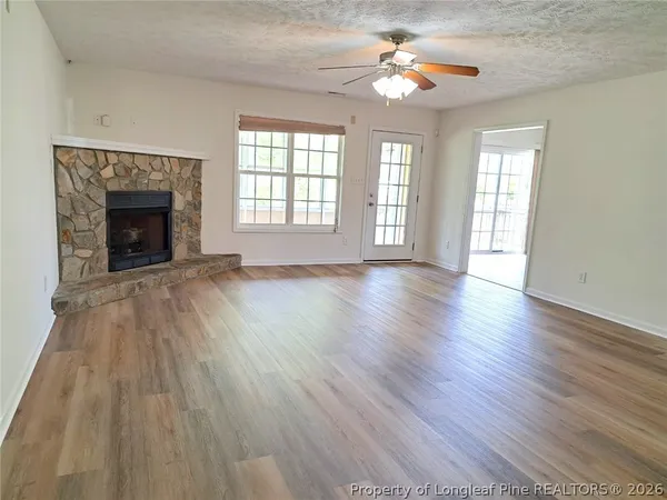 wooden floor fireplace and windows in an empty room