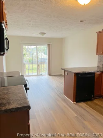 a kitchen with granite countertop a stove and a wooden floor