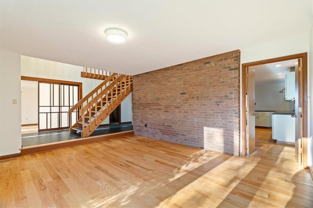 3 Partridge Court Sewickley, PA 15143 - Photo 9 of 50 a view of an empty room with wooden floor and stairs