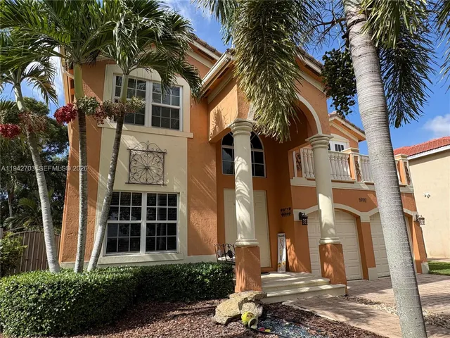 a front view of a house with a tree