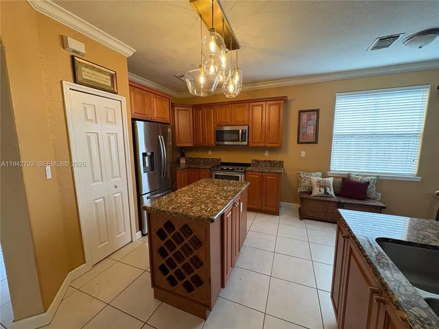 a kitchen with stainless steel appliances granite countertop a stove refrigerator and a sink