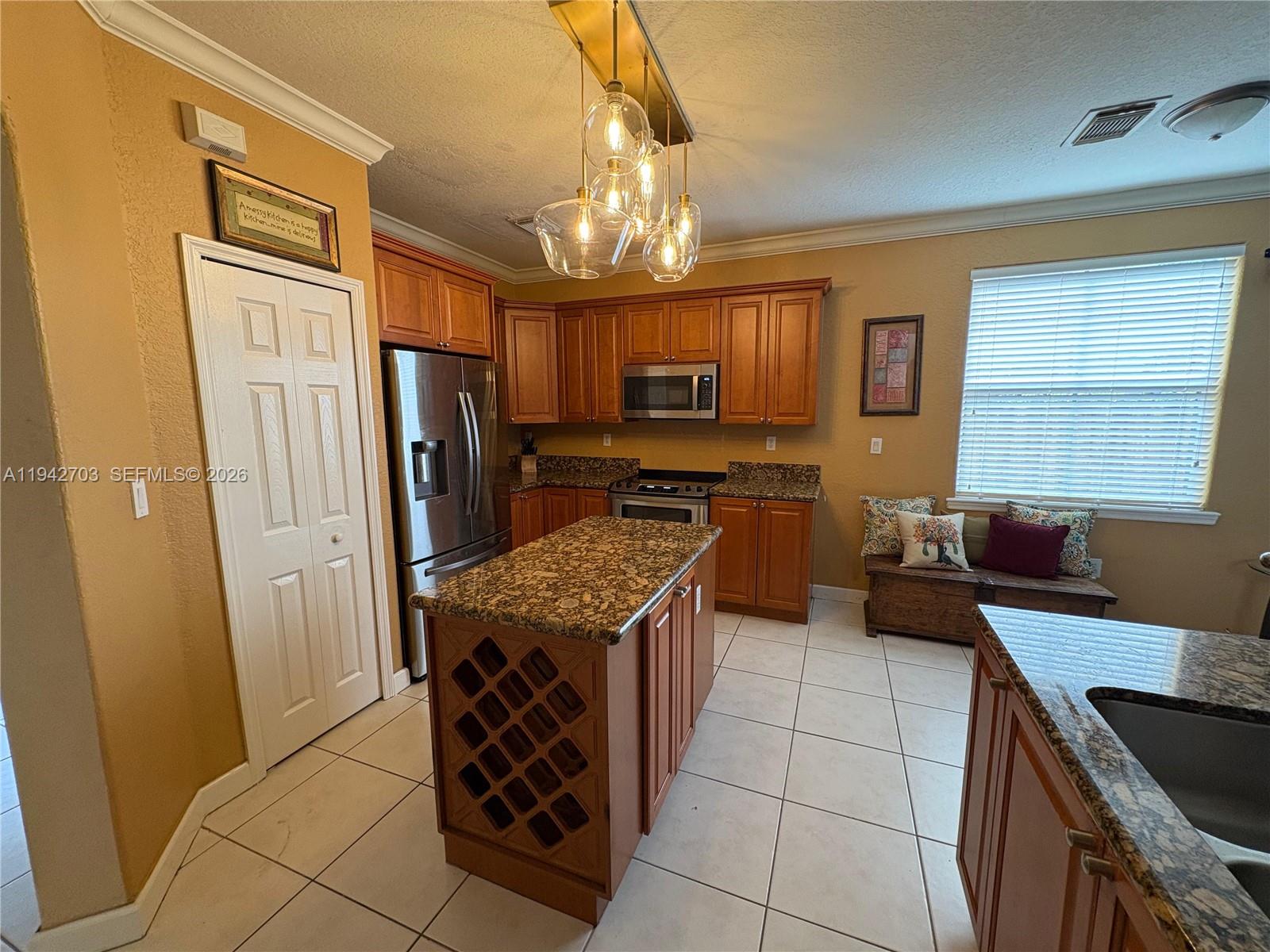 5902 Southwest 166th Court Miami, FL 33193 - Photo 6 of 27 a kitchen with stainless steel appliances granite countertop a stove refrigerator and a sink