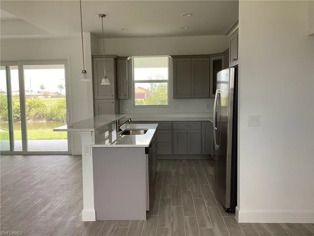 a kitchen with kitchen island a counter top space a sink and appliances