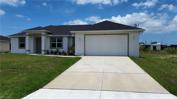 a front view of a house with a garden and yard