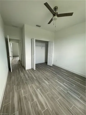 a view of a livingroom with wooden floor and a ceiling fan