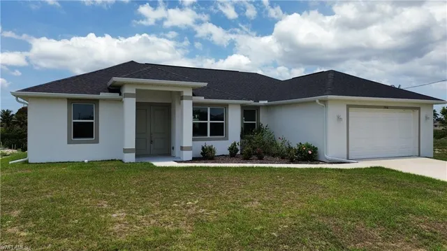 a front view of a house with a yard and garage