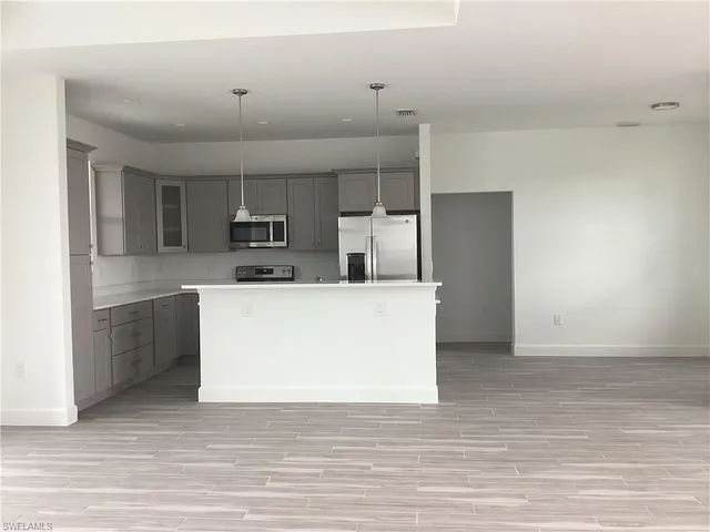 a large white kitchen with cabinets