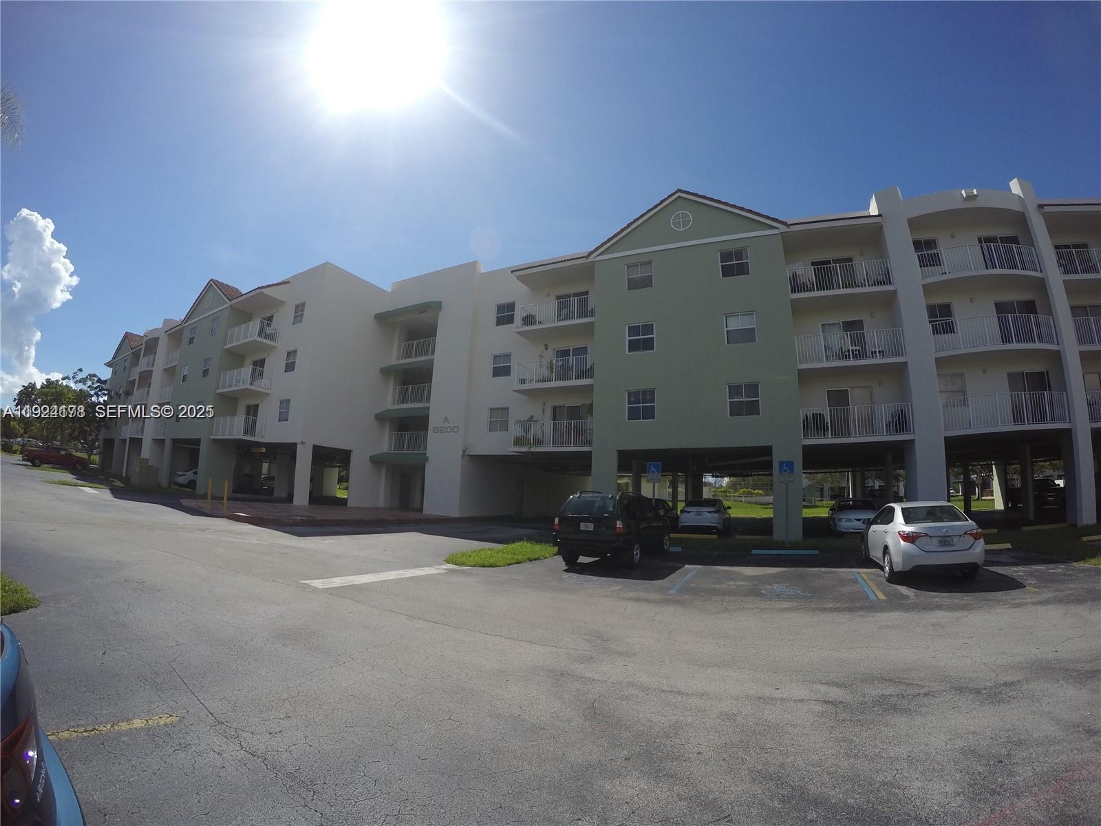 8200 Southwest 210th Street, Unit 320 Cutler Bay, FL 33189 - Photo 1 of 14 a front view of a building with cars parked