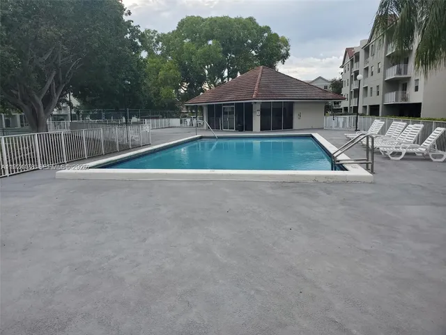 a living room with patio furniture and a garden