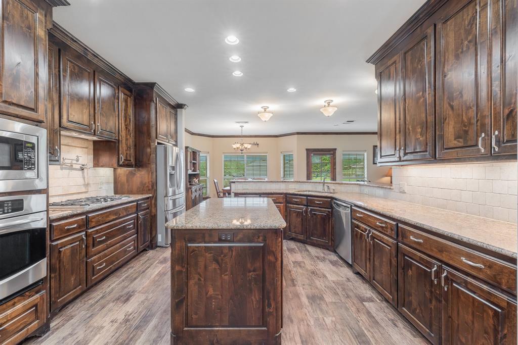 289 Blackjack Road Valley View, TX 76272 - Photo 16 of 40 a kitchen with stainless steel appliances granite countertop wooden cabinets a sink dishwasher a stove and a refrigerator