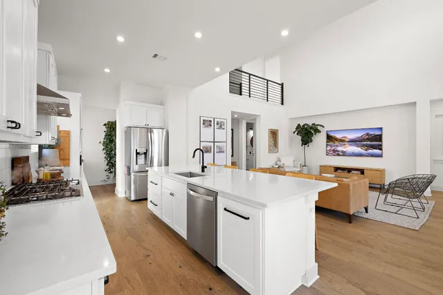 a large white kitchen with stainless steel appliances