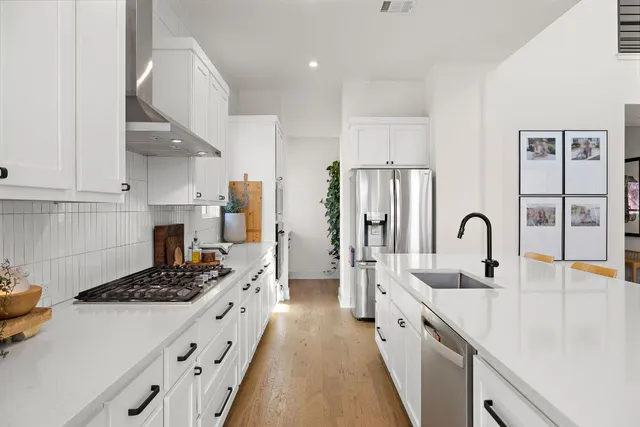 a kitchen with stainless steel appliances a sink stove and cabinets
