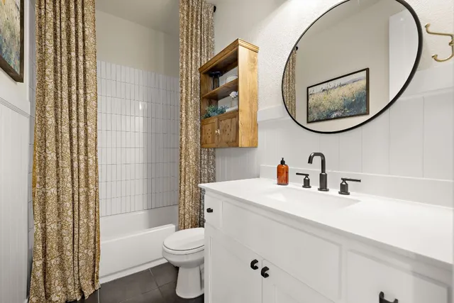 a bathroom with a sink a mirror a toilet and a shower