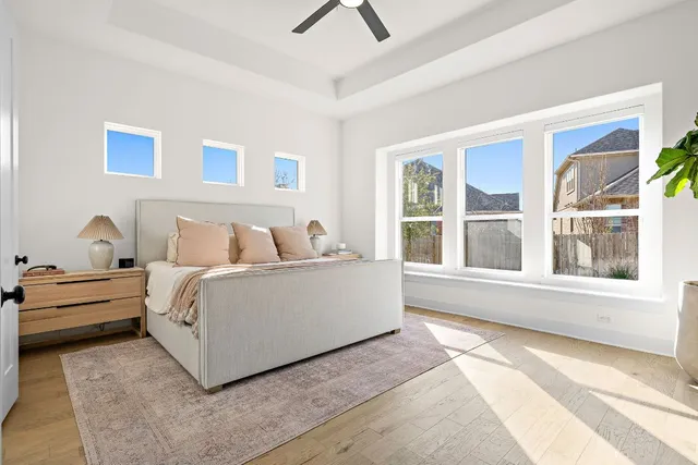 a white bed sitting in a bedroom next to a window
