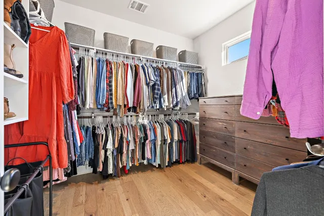 a view of walk in closet with clothes