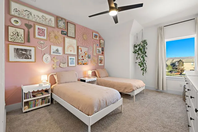 a bedroom with two beds and potted plant on the dresser