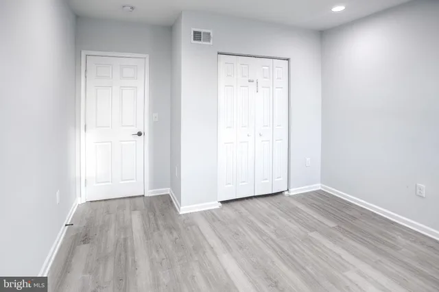 an empty room with wooden floor and closet
