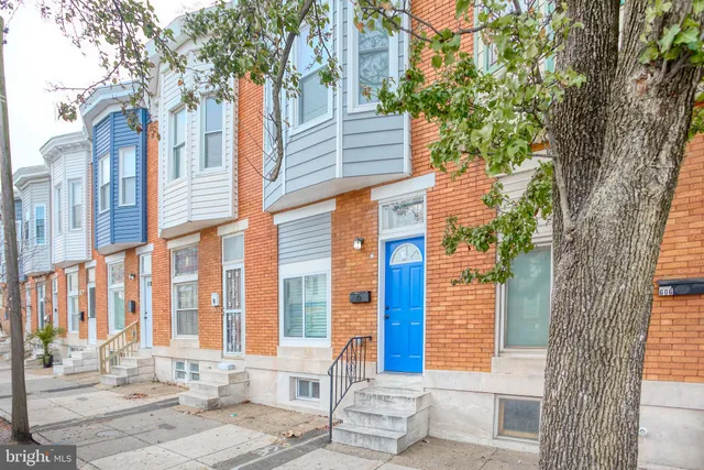 a front view of a building with a tree