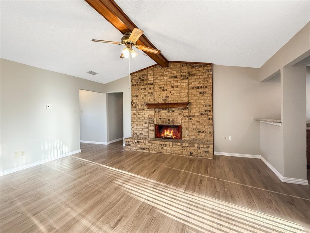 3614 Colbath Drive Garland, TX 75040 - Photo 2 of 24 a view of an empty room with wooden floor fireplace and a window