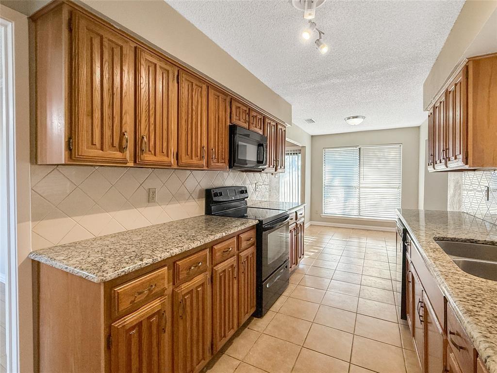 3614 Colbath Drive Garland, TX 75040 - Photo 5 of 24 a kitchen with stainless steel appliances granite countertop a stove a sink and a microwave