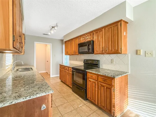 a kitchen with stainless steel appliances granite countertop a stove a sink and a microwave