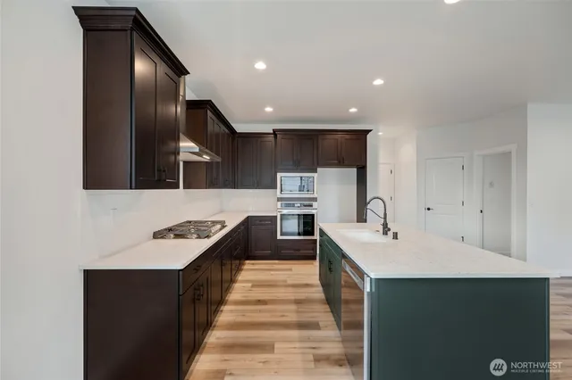 a kitchen with stainless steel appliances a sink stove and cabinets