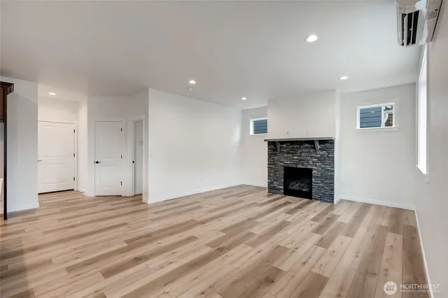 a view of empty room with wooden floor and fireplace