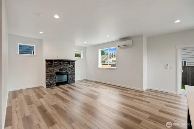 a view of empty room with wooden floor and fireplace