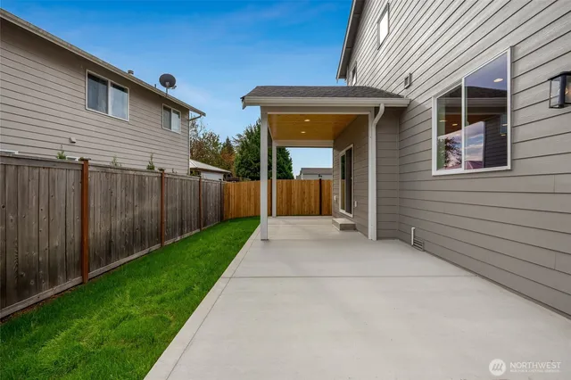 a view of backyard with potted plants and wooden fence