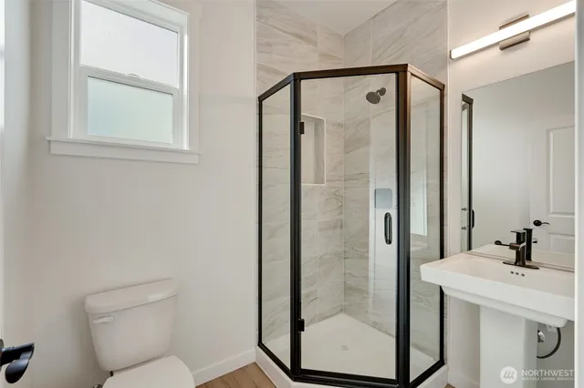 a bathroom with a shower sink vanity and toilet