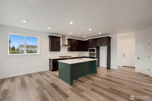 a view of kitchen with stainless steel appliances granite countertop a stove and a refrigerator