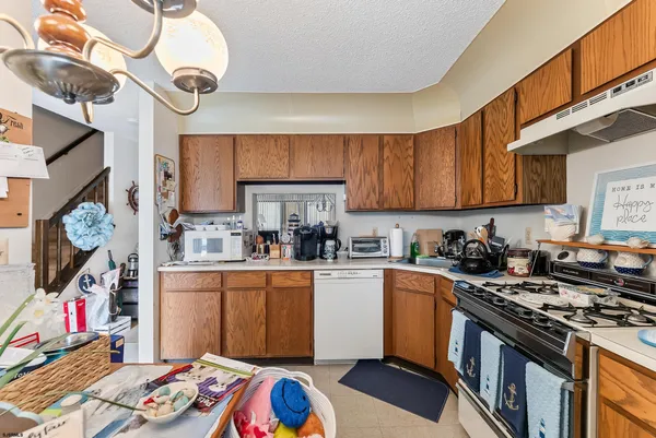 a kitchen with stainless steel appliances granite countertop a stove a sink dishwasher and cabinets with wooden floor