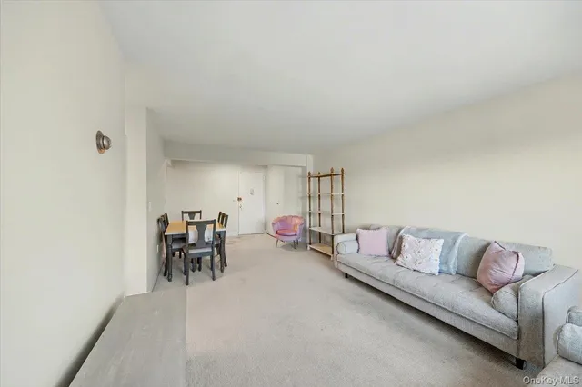 a living room with furniture and a dining table with a large window