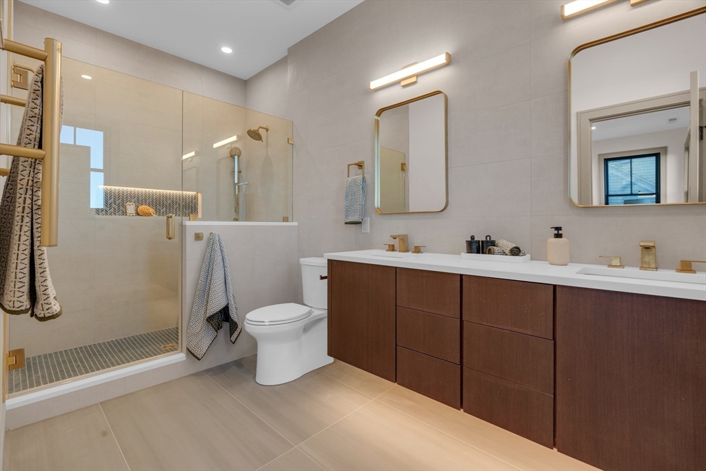 151 Mason Terrace, Unit 2 Brookline, MA 02446 - Photo 12 of 21 a bathroom with a double vanity sink toilet and shower