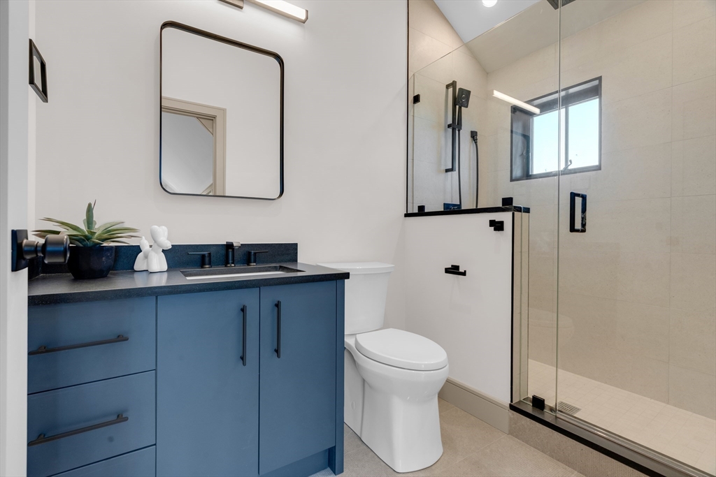 151 Mason Terrace, Unit 2 Brookline, MA 02446 - Photo 21 of 21 a bathroom with a toilet a sink a vanity and mirror