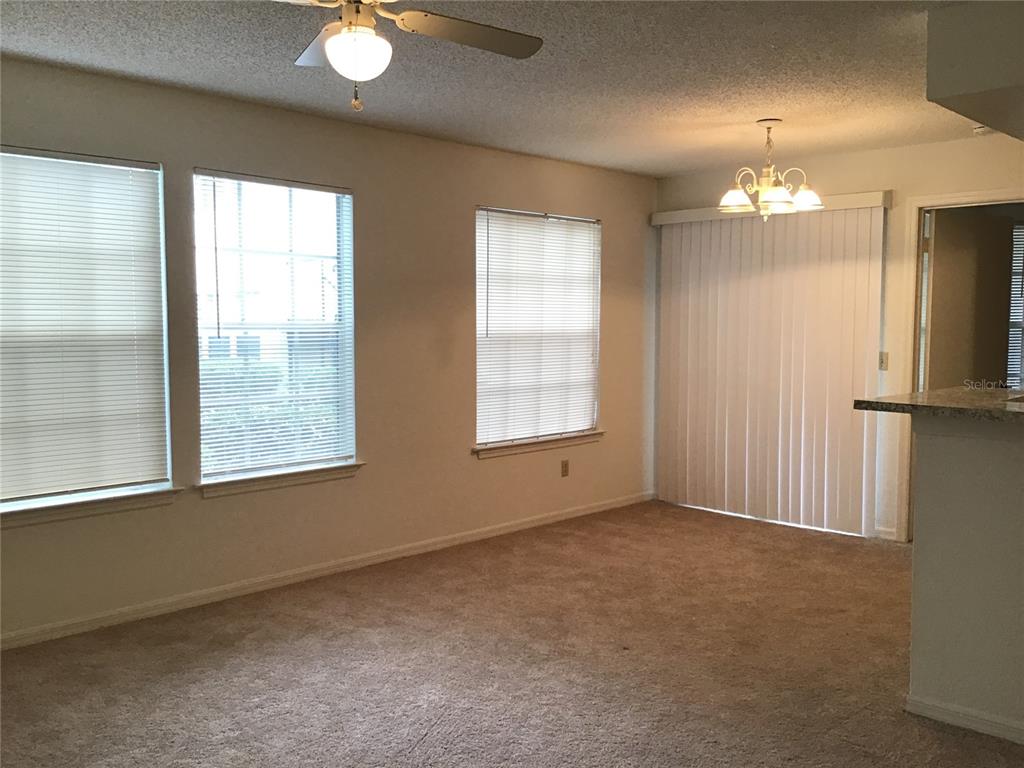 1029 South Hiawassee Road, Unit 2412 Orlando, FL 32835 - Photo 2 of 20 an empty room with chandelier fan and windows