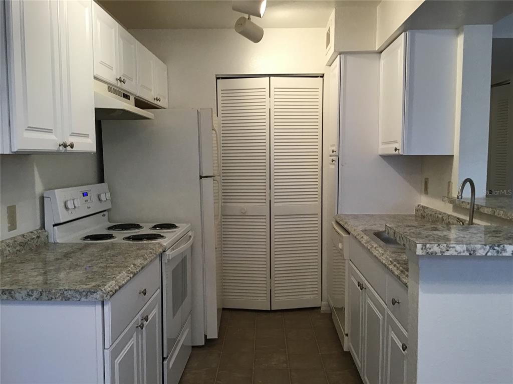 1029 South Hiawassee Road, Unit 2412 Orlando, FL 32835 - Photo 5 of 20 a kitchen with stainless steel appliances granite countertop a sink stove and refrigerator