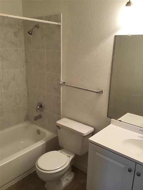 1029 South Hiawassee Road, Unit 2412 Orlando, FL 32835 - Photo 10 of 20 a white toilet and tub sitting next to a bathroom sink