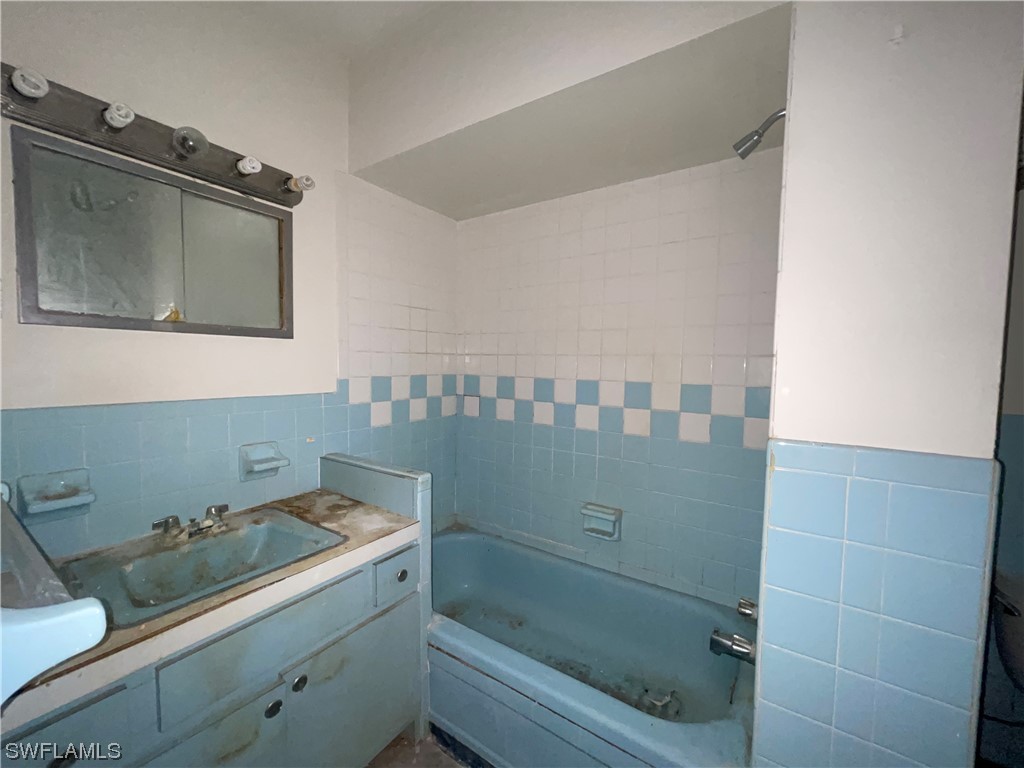 1107 Patterson Road Cape Coral, FL 33909 - Photo 16 of 35 a bathroom with a bathtub sink and mirror